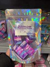 Load image into Gallery viewer, A clear gift bag filled with colorful handmade birthday cake fizzing bath bomb rocks with a decorative product label.
