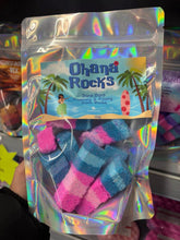 Load image into Gallery viewer, A clear gift bag filled with colourful handmade blue and pink Ohana rocks bath bomb chunks with a tropical theme label.
